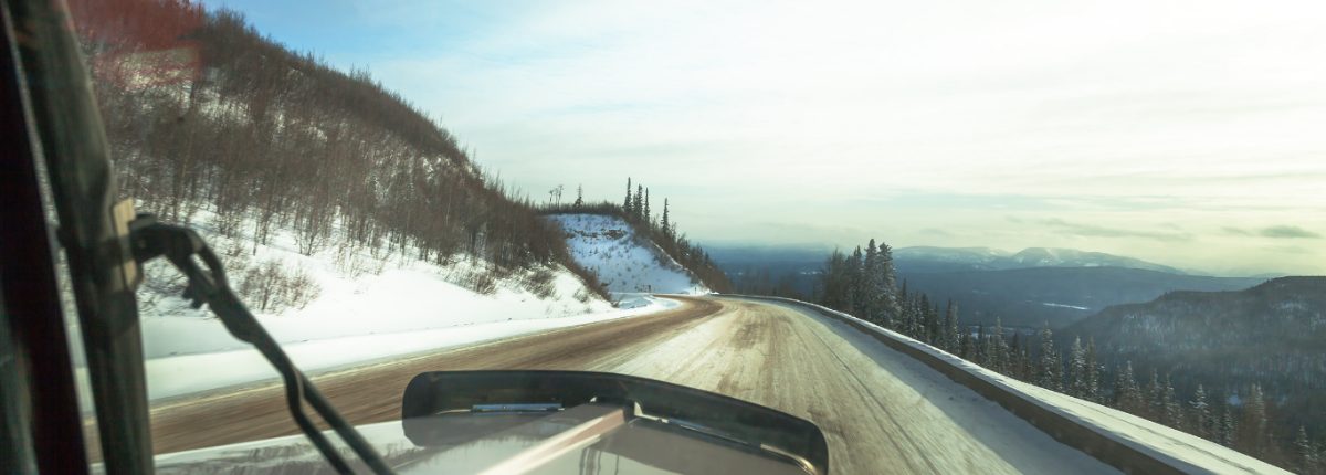 Driver view through the windshield on a snowy mountain road